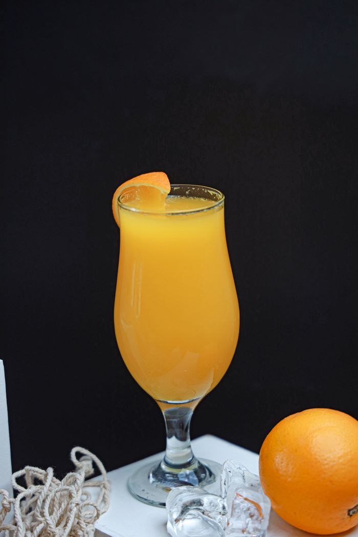 Chilled glass of fresh orange juice garnished with orange slice, perfect for a healthy lifestyle.