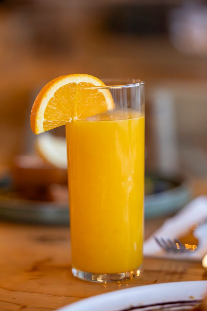A vibrant glass of orange juice with a fresh orange slice for a healthy refreshment.