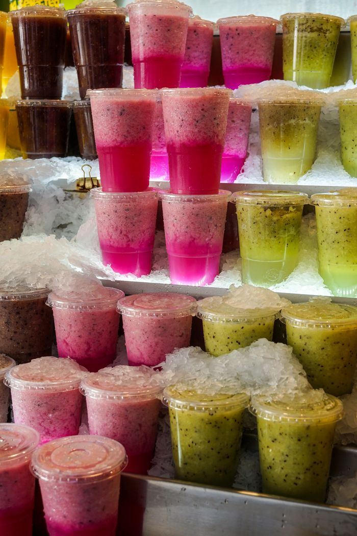 Colorful assortment of fresh fruit smoothies on ice. Perfect for summer refreshment.